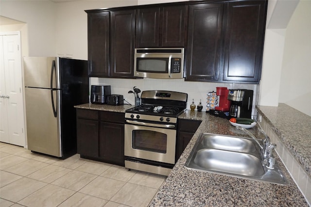 1608 Grable Cove Ln, Spring, TX 77379 - kitchen with appliances with stainless steel finishes, a sink, light tile patterned flooring, and decorative backsplash