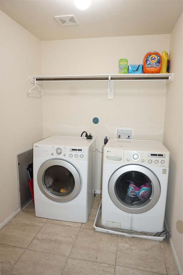 1608 Grable Cove Ln, Spring, TX 77379 - washroom with washer and dryer, baseboards, and light tile patterned flooring