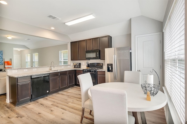 23607 Buttress Root Dr, Spring, TX 77373 - kitchen featuring black appliances, lofted ceiling, a sink, dark brown cabinets, and a peninsula