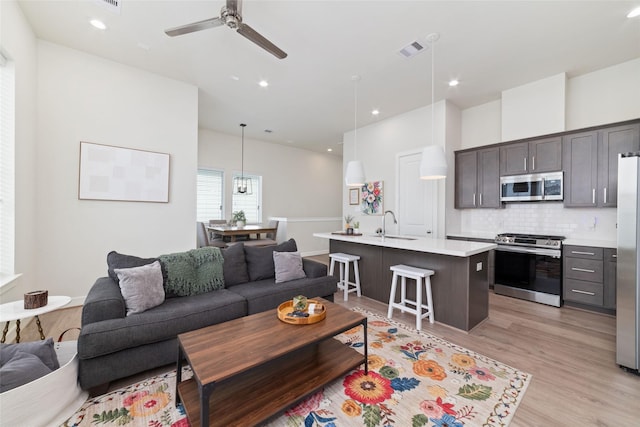 6307 Chelsea Falls Ln, Houston, TX 77008 - living area featuring light wood finished floors, ceiling fan, and recessed lighting