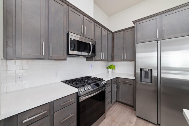 6307 Chelsea Falls Ln, Houston, TX 77008 - kitchen featuring appliances with stainless steel finishes, light wood-style flooring, light countertops, decorative backsplash, and dark brown cabinetry