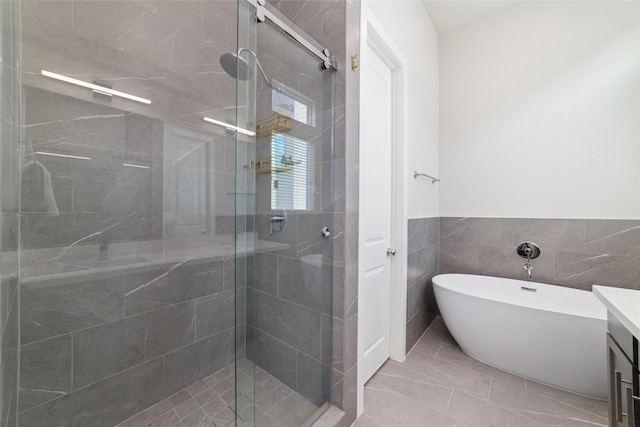 6307 Chelsea Falls Ln, Houston, TX 77008 - bathroom featuring a stall shower, vanity, a freestanding tub, tile walls, and wainscoting