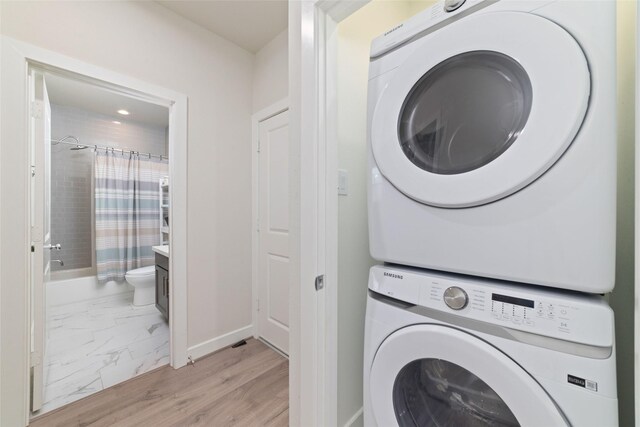 6307 Chelsea Falls Ln, Houston, TX 77008 - laundry area featuring stacked washer / drying machine, baseboards, and light marble finish flooring