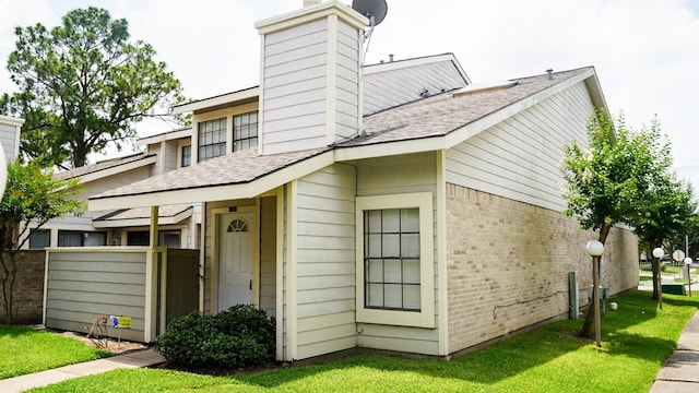 11881 Bob White Dr Unit 828, Houston, TX 77035 - view of front facade with a chimney, a shingled roof, and brick siding