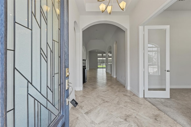 13303 Itasca Pine Dr, Humble, TX 77346 - foyer entrance with arched walkways, a chandelier, and baseboards