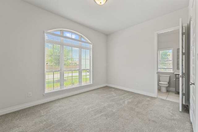 13303 Itasca Pine Dr, Humble, TX 77346 - unfurnished bedroom featuring light carpet, baseboards, and ensuite bathroom