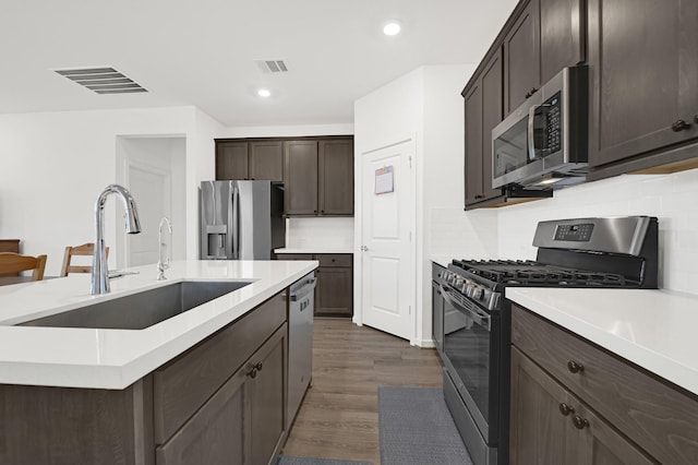 21746 Heather Elm Dr, Cypress, TX 77433 - kitchen featuring appliances with stainless steel finishes, a sink, dark brown cabinets, light countertops, and dark wood-style floors