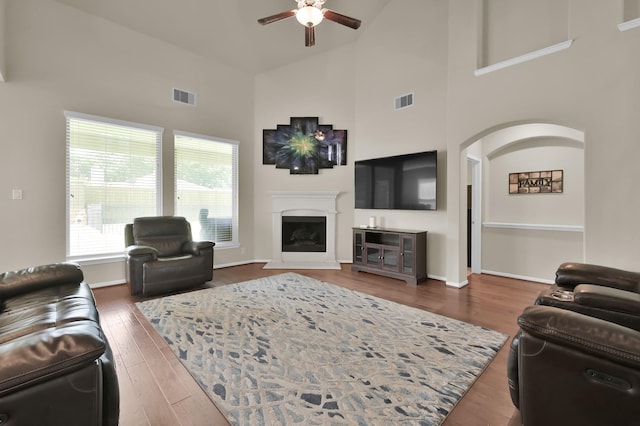 5015 Gold Lantana Trl, Spring, TX 77389 - living room with a ceiling fan, high vaulted ceiling, wood finished floors, arched walkways, and a fireplace with raised hearth