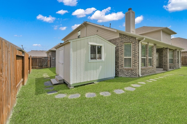 5015 Gold Lantana Trl, Spring, TX 77389 - back of property featuring a chimney, brick siding, and an outbuilding