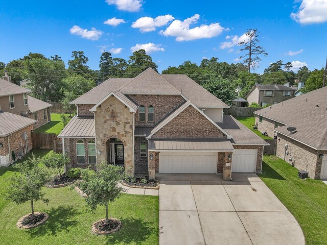 5015 Gold Lantana Trl, Spring, TX 77389 - view of front of house with a standing seam roof, brick siding, driveway, a shingled roof, and an attached garage
