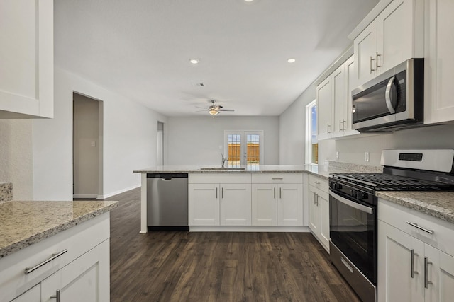 10347 Red Cardinal Dr, Cleveland, TX 77328 - kitchen with appliances with stainless steel finishes, a sink, a peninsula, ceiling fan, and dark wood finished floors