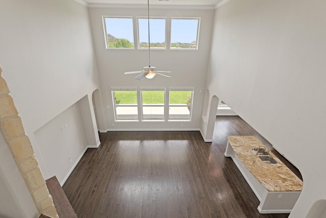 2131 Cranbrook Ridge Ln, Sugar Land, TX 77479 - unfurnished living room with ceiling fan, baseboards, wood finished floors, arched walkways, and a high ceiling