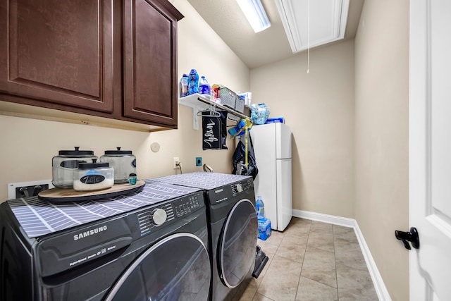 18610 Fairmont Springs Ct, Cypress, TX 77429 - laundry area with attic access, independent washer and dryer, cabinet space, baseboards, and light tile patterned flooring