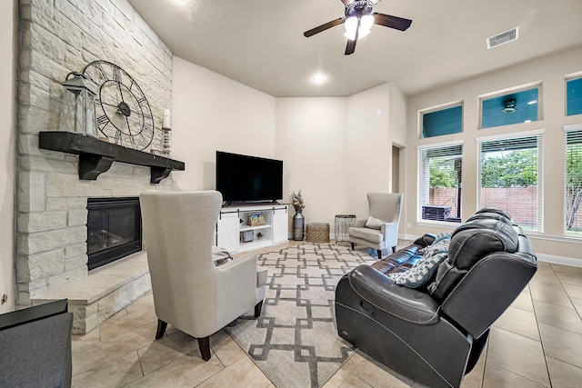 18610 Fairmont Springs Ct, Cypress, TX 77429 - living area with a stone fireplace, a ceiling fan, tile patterned floors, and baseboards