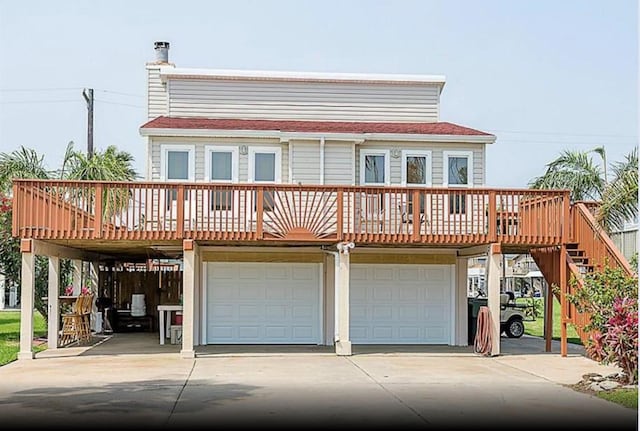 4126 Fort Bend Dr, Galveston, TX 77554 - view of front facade featuring an attached garage, concrete driveway, stairway, and a deck