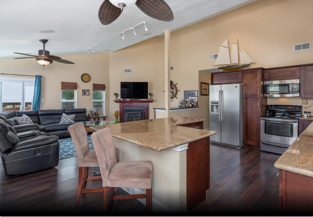 4126 Fort Bend Dr, Galveston, TX 77554 - kitchen with stainless steel appliances, ceiling fan, dark wood finished floors, open floor plan, and high vaulted ceiling