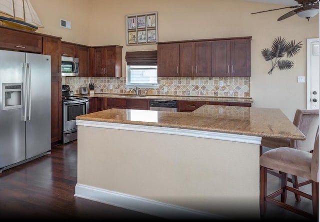 4126 Fort Bend Dr, Galveston, TX 77554 - kitchen with appliances with stainless steel finishes, a sink, dark wood-style floors, ceiling fan, and backsplash