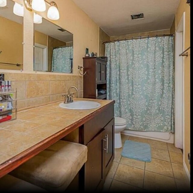 4126 Fort Bend Dr, Galveston, TX 77554 - bathroom featuring vanity, toilet, tasteful backsplash, and a shower with shower curtain