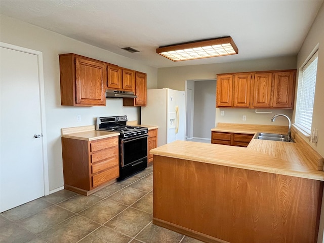 6619 Stonechase, Houston, TX 77084 - kitchen featuring gas stove, under cabinet range hood, a sink, a peninsula, and light countertops