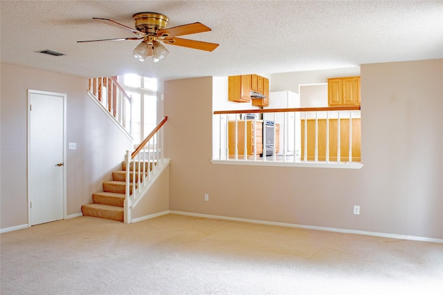 6619 Stonechase, Houston, TX 77084 - unfurnished living room with carpet, ceiling fan, stairway, baseboards, and a textured ceiling
