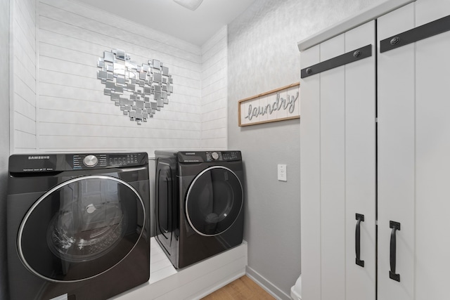 14027 Valley Creek Ct, Conroe, TX 77384 - laundry room featuring washer and clothes dryer, light wood-style flooring, and baseboards