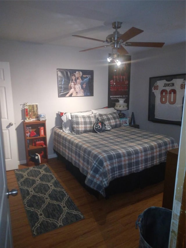 4802 Holly St, Bellaire, TX 77401 - bedroom featuring wood finished floors, a ceiling fan, and baseboards