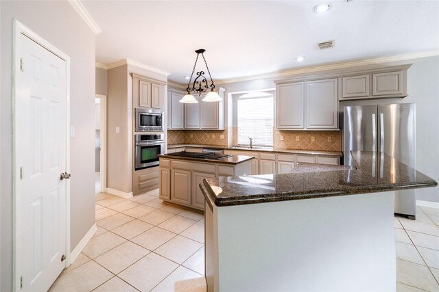 8907 Opus Ct, Houston, TX 77040 - kitchen featuring appliances with stainless steel finishes, a kitchen island, a sink, light tile patterned floors, and decorative backsplash