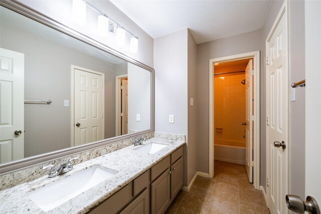 8907 Opus Ct, Houston, TX 77040 - bathroom featuring double vanity, baseboards, tile patterned flooring, and washtub / shower combination