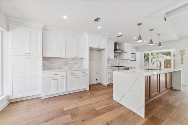 2618 Pine Village Dr, Houston, TX 77080 - kitchen with wall chimney exhaust hood, white cabinetry, decorative backsplash, a sink, and light wood-style flooring