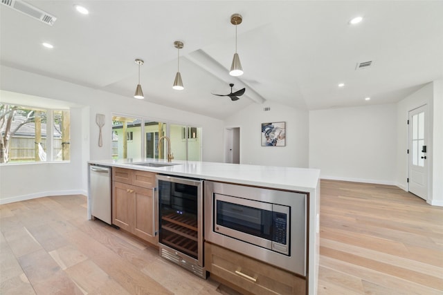 2618 Pine Village Dr, Houston, TX 77080 - kitchen featuring wine cooler, a sink, stainless steel appliances, light wood-style flooring, and baseboards