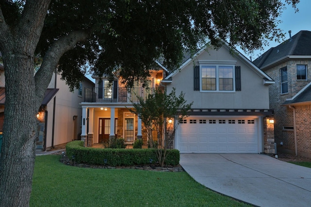 12336 Pebble View Dr, Conroe, TX 77304 - view of front of property with a balcony, concrete driveway, an attached garage, a front lawn, and stone siding