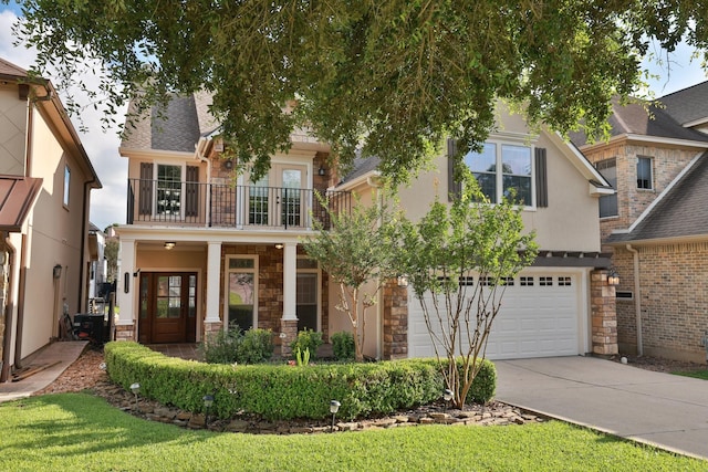12336 Pebble View Dr, Conroe, TX 77304 - view of front of house featuring a balcony, stone siding, concrete driveway, a garage, and stucco siding