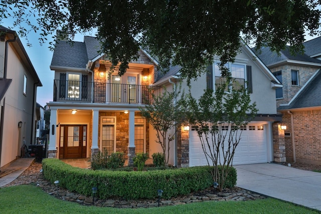 12336 Pebble View Dr, Conroe, TX 77304 - view of front of house featuring a balcony, stone siding, driveway, a garage, and stucco siding