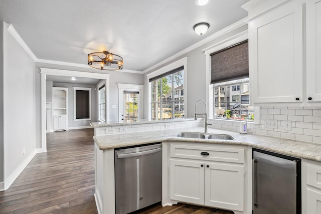 12336 Pebble View Dr, Conroe, TX 77304 - kitchen featuring stainless steel dishwasher, a sink, crown molding, a peninsula, and tasteful backsplash
