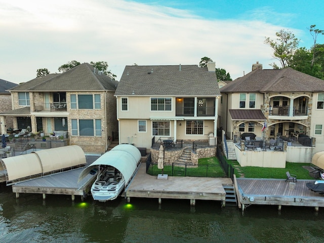 12336 Pebble View Dr, Conroe, TX 77304 - back of property featuring a fenced backyard, a water view, a patio, and stucco siding