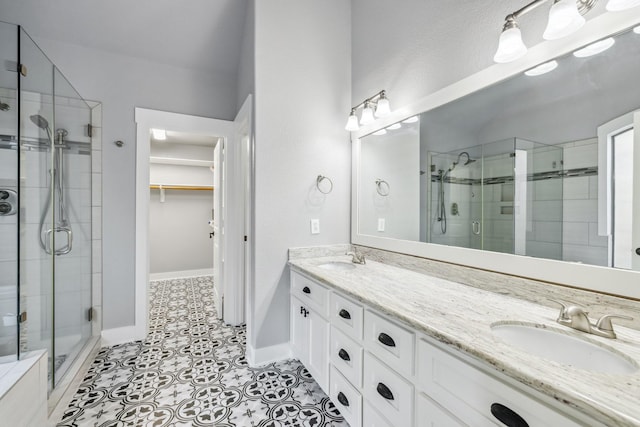 12336 Pebble View Dr, Conroe, TX 77304 - bathroom with a stall shower, double vanity, a walk in closet, and tile patterned flooring