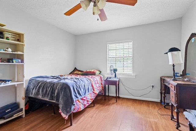 24027 Spears Cir, New Caney, TX 77357 - bedroom with wood finished floors, a textured ceiling, ceiling fan, and baseboards