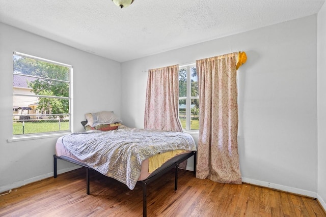 24027 Spears Cir, New Caney, TX 77357 - bedroom with wood finished floors, baseboards, and a textured ceiling