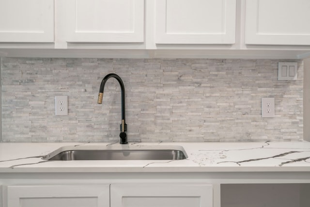 15608 Navajo Trl, Willis, TX 77378 - kitchen view of a sink, backsplash, and white cabinets