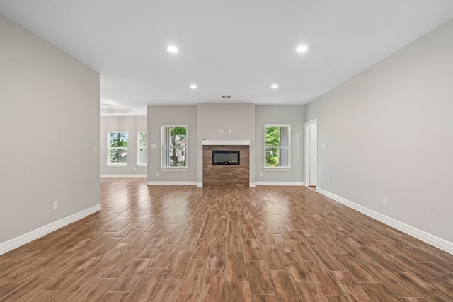 15608 Navajo Trl, Willis, TX 77378 - unfurnished living room with baseboards, wood finished floors, recessed lighting, and a fireplace
