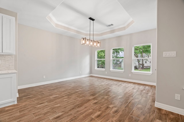 15608 Navajo Trl, Willis, TX 77378 - empty room featuring a raised ceiling, wood finished floors, baseboards, and crown molding
