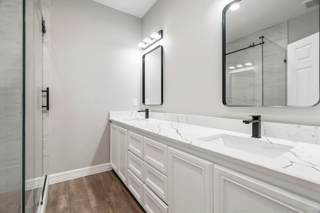 15608 Navajo Trl, Willis, TX 77378 - bathroom featuring a shower stall, double vanity, wood finished floors, and baseboards