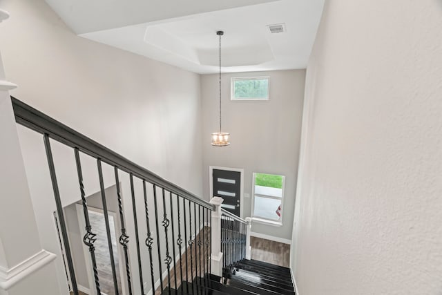 15608 Navajo Trl, Willis, TX 77378 - staircase with a tray ceiling, wood finished floors, baseboards, and a chandelier