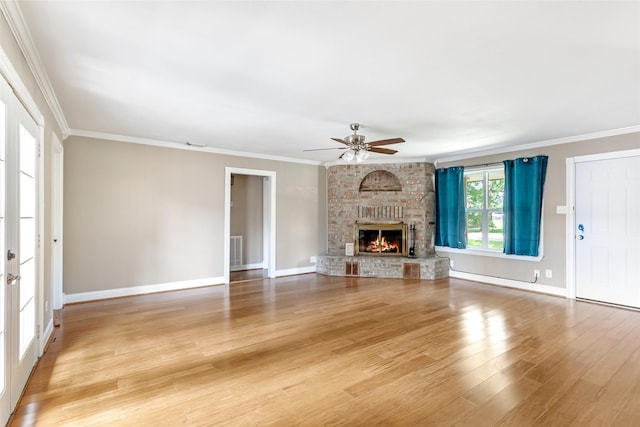 2198 N Winfree St, Dayton, TX 77535 - unfurnished living room with a ceiling fan, crown molding, light wood-type flooring, a brick fireplace, and baseboards