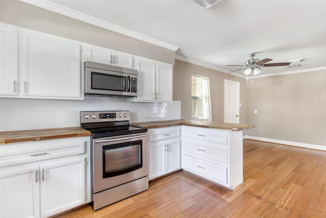 2198 N Winfree St, Dayton, TX 77535 - kitchen featuring stainless steel appliances, butcher block countertops, a peninsula, backsplash, and ornamental molding