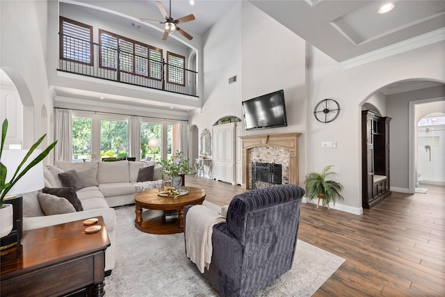 11 Bees Creek Ct, Missouri City, TX 77459 - living room featuring a high ceiling, ceiling fan, a fireplace, wood finished floors, and ornamental molding