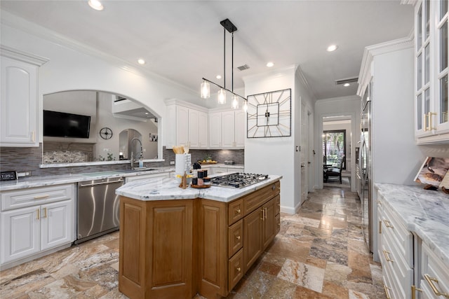 11 Bees Creek Ct, Missouri City, TX 77459 - kitchen featuring appliances with stainless steel finishes, glass insert cabinets, crown molding, a sink, and white cabinetry