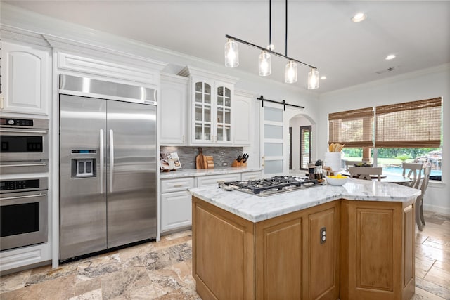 11 Bees Creek Ct, Missouri City, TX 77459 - kitchen featuring appliances with stainless steel finishes, stone tile floors, ornamental molding, arched walkways, and glass insert cabinets