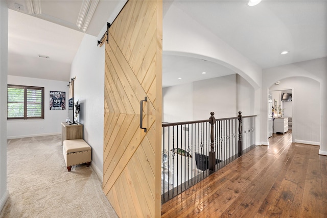 11 Bees Creek Ct, Missouri City, TX 77459 - corridor featuring a barn door, baseboards, hardwood / wood-style flooring, recessed lighting, and arched walkways