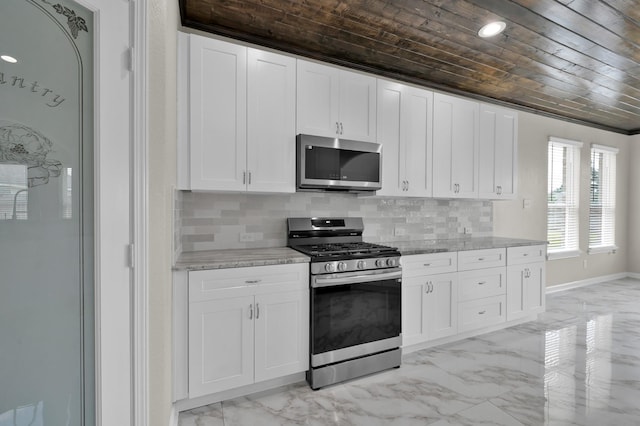 30507 Woodson Trace Dr, Spring, TX 77386 - kitchen featuring stainless steel appliances, wooden ceiling, light marble finish floors, white cabinets, and baseboards